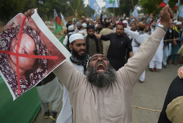 Un militant du parti islamiste radical Ahle Sunnat Wal Jamaat (ASWJ) tient une image d’Asia Bibi lors d’une manifestation contre son acquittement par la Cour Suprême du pays. Islamabad le 2 novembre 2018