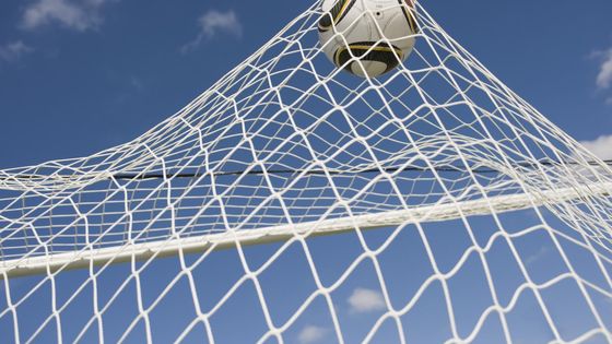 Un ballon au fond des filets sur un terrain de football. - MAXPPP