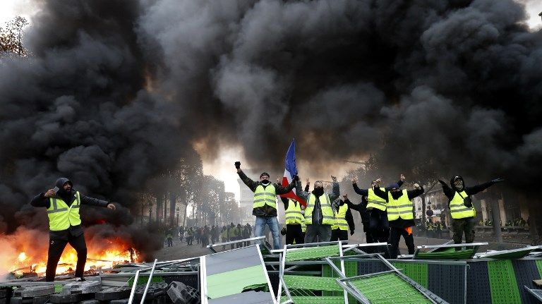 Les Gilets jaunes, sur une barricade improvisée proche de l'Arc de Triomphe, à Paris.