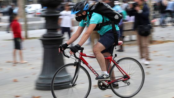 Chauffeur-livreur de la société de livraison de nourriture à domicile Deliveroo lors d'un rassemblement le 11 août 2017 à Paris pour demander une augmentation de salaire pour des déplacements supplémentaires ©AFP - Jacques Demarthon
