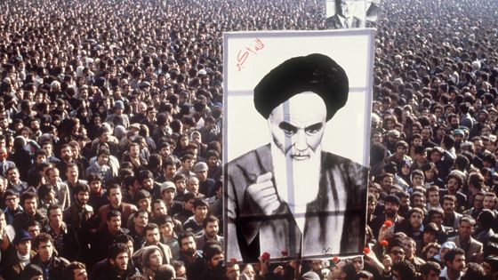 A Téhéran durant la révolution de 1979, des manifestants tiennent une affiche de l'ayatollah Khomeiny ©AFP - AFP
