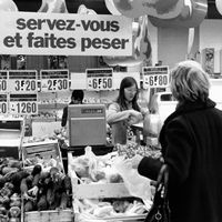 Clients faisant leurs courses au rayon des légumes d'un supermarche en 1980