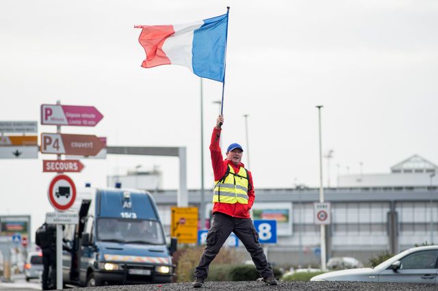 Un manifestant brandit un drapeau français près de l'aéroport de Nantes lors d'une manifestation de Gilets jaunes, à Bouguenais le 8 décembre 2018