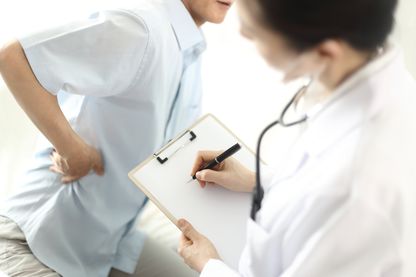 Doctor checking patient's back Doctor checking patient's back