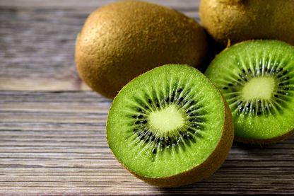 Kiwi frais tranchés sur une table en bois Kiwi frais tranchés sur une table en bois