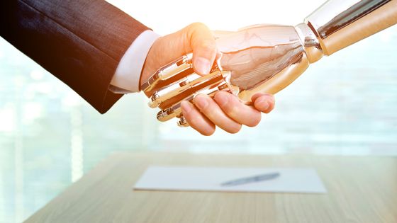 Homme d'affaire serrant la main d'un robot ©Getty - Libre de droits