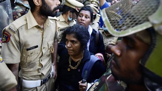 Une escorte policière protège les deux jeunes femmes du lynchage, après être entrées dans le temple sacré de Sabarimala consacré au dieu Ayappa ©AFP - AFP