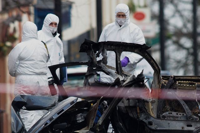 Des experts de la police scientifique examinent la carcasse du vehicule piégé qui a explosé le 19 janvier à Londonderry
