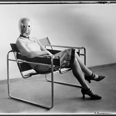 Femme portant un masque de théâtre d’Oskar Schlemmer, assise sur une chaise en acier tubulaire de Marcel Breuer, 1926.