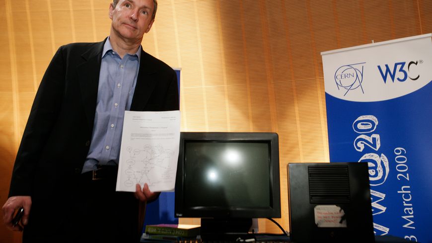 Tim Berners-Lee, l'inventeur du web, pose à côté du premier ordinateur ayant été utilisé comme serveur pour diffuser le world wide web. Photo prise en 2009 au siège du CERN à Genève.