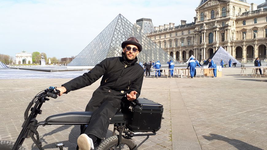JR devant la pyramide du Louvre, pendant l'installation de son collage géant au sol
