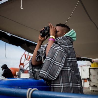Depuis le bateau de sauvetage néerlandais Sea Watch 3, un mineur non accompagné regarde la côte italienne à travers des jumelles.