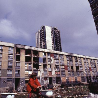 Petites filles jouant devant des immeubles endommagés par le siège de Sarajevo en mars 1996 (Bosnie-Herzégovine)