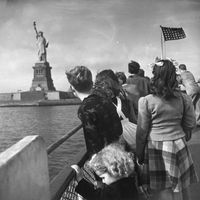 Enfants réfugiés regardant la Statue de la Liberté depuis la rambarde d'un bateau