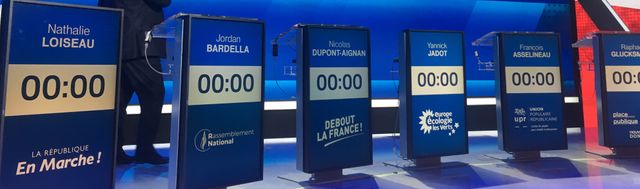 Une partie des pupitres des candidats disposés en arc de cercle sur le plateau de l'Émission politique.