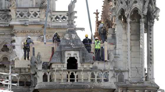 Pompiers et experts inspectent Notre-Dame de Paris ravagée par les flammes lundi soir ©Maxppp - Eco Clément