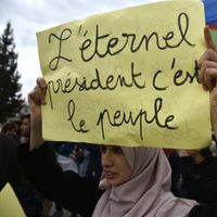 Une femme algérienne manifestate contre le président Abdelaziz Bouteflika ; sur sa pancarte on peut lire "L'éternel président c'est le peuple"