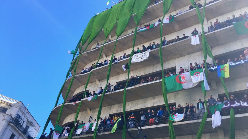 A Alger, le 15 mars 2019, drapeaux algériens et foule aux balcons, dans le quartier de la grande Poste