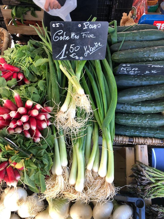 Botte de cébettes nouvelles sur un étal au marché.