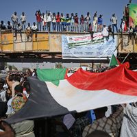 Des manifestants soudanais agitent le drapeau national lors d'un rassemblement géant devant le quartier général de l'armée à Khartoum, la capitale. (25/04/19)