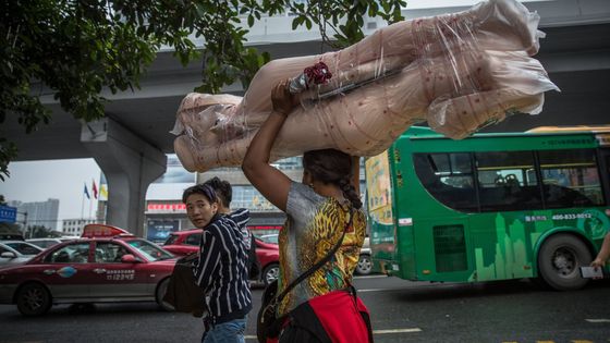 Une femme Africaine porte un mannequin sur sa tête à Guangzhou, Guangdong province, Chine, 15.11.2017 A partir des années 1990 et dans les années 2000, la communauté d'expatriés et de migrants a grandi formant une "Petite Afrique" ©Maxppp - ROMAN PILIPEY/EPA/Newscom/MaxPPP