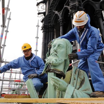 Des ouvriers de la compagnie Socra, spécialisée dans la conservation d'oeuvres d'art, procèdent au retrait de la statue de l'apôtre Saint André de la cathédrale Notre-Dame de Paris, pour pouvoir procéder à sa restauration, le 27 mars 2019.