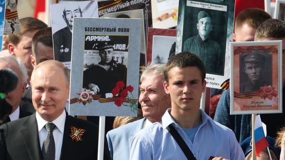 Vladimir Poutine porte le portrait de son père, Vladimir Spiridonovich Poutine (1911-1998), qui a combattu pendant la Seconde Guerre mondiale, prenant part à la marche du Régiment Immortel Place Rouge à Moscou.. ©Getty - Alexei Druzhinin /TASS