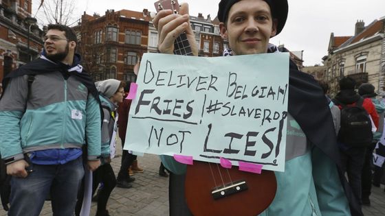 « Libérez les frites belges et non les mensonges ! », tel est le message d'un employé de Deliveroo lors d'une manifestation pour demander un meilleur statut le 27 janvier 2018 à Bruxelles. ©AFP - NICOLAS MAETERLINCK / BELGA