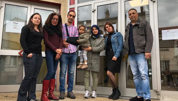Yacine, le bras en écharpe, avec sa famille, son ami Sofiane et les membres du centre social La Rivière de Saint-Etienne