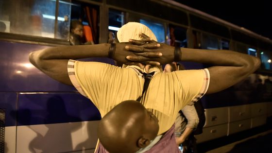 Migrants du Niger s'apprêtant à monter dans un bus pour être rapatriés dans leur pays par les Autorités algériennes, 2 juillet 2018, dans un centre de transit pour migrants au Sud de l'Algérie ©AFP - RYAD KRAMDI