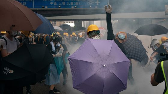 A protester throw a teargas canister to the police as another protester holds an umbrella during a demonstration on June 12, 2019 in Hong Kong ©Getty - Anthony Kwan