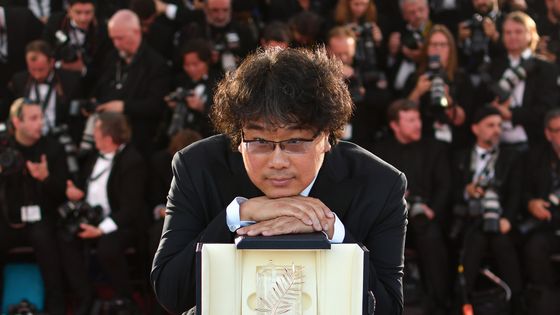 Le réalisateur et scénariste Bong Joon-ho, avec son trophée après avoir remporté la Palme d'Or du film "Parasite (Gisaengchung)" le 25 mai 2019 à Cannes. ©AFP - Alberto PIZZOLI