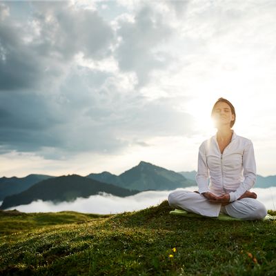 Une femme en pleine méditation au sommet d'une montagne