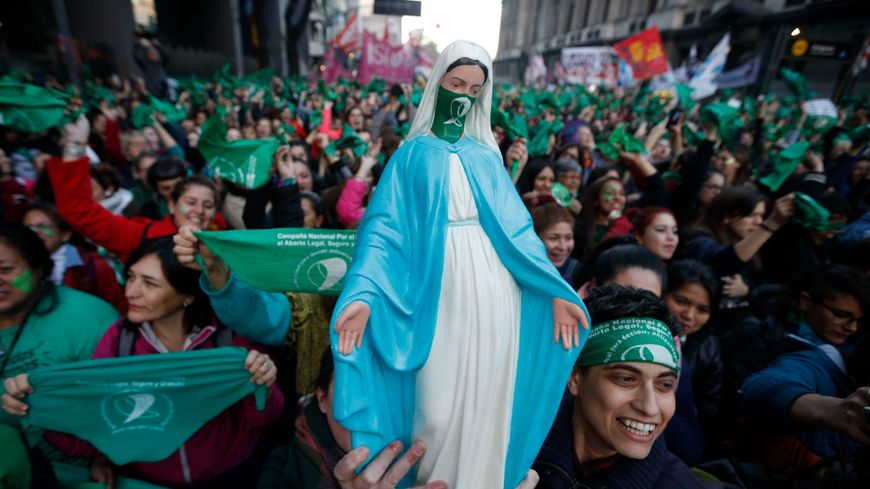 Des femmes brandissent leurs foulards verts et une statuette de la Vierge muselée de vert pour la légalisation de l'avortement, devant le Congrès argentin à Buenos Aires, le 28 mai 2019