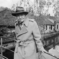 Louis Aragon devant sa maison à Moulin de Villeneuve, offerte à Elsa Triolet