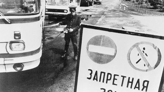 un policier contrôle, le 10 mai 1986, le niveau de radioactivité de véhicules quittant la zone interdite de 30 km autour de la centrale nucléaire de Tchernobyl, quelques jours après l'explosion du réacteur No 4 de l'installation, le 26 avril 1986 ©AFP - STF/AFP