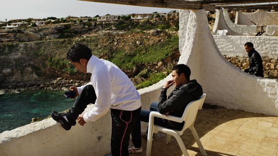 Les immigrants tunisiens à Lampedusa sur la terrasse d'une maison ©AFP - AFP PHOTO / ROBERTO SALOMONE