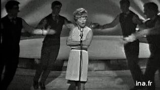 12 mai 1966, Mick Micheyl (1922-2019) en meneuse de revue entourée de danseurs - Ina Chansons