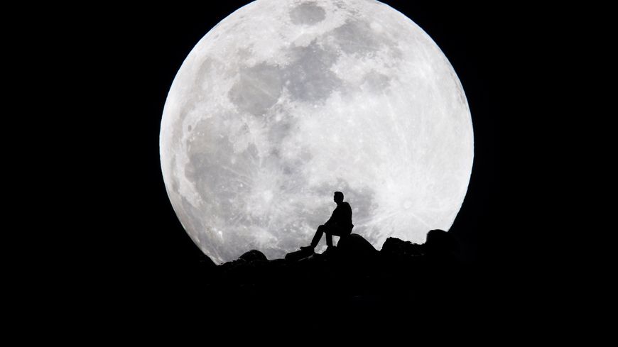 Une silhouette face à la lune.