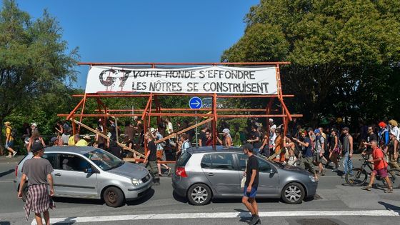 Les manifestants défilent avec une banderole sur laquelle on pouvait lire: "Le G7, votre monde s'effondre, les nôtres se construisent" à Hendaye le 22 août 2019 lors d'un rassemblement contre le sommet du Groupe des Sept (G7) ©AFP - Ander Gillenea