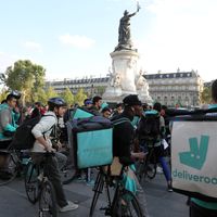 Des livreurs à vélo de la plateforme de livraison Deliveroo sont rassemblés pour demander une hausse des salaires, le 11 août 2017 sur la place de la République à Paris.