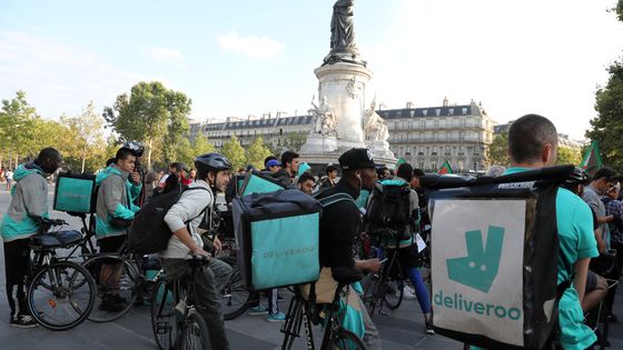 Des livreurs à vélo de la plateforme de livraison Deliveroo sont rassemblés pour demander une hausse des salaires, le 11 août 2017 sur la place de la République à Paris. ©AFP - Jacques Demarthon