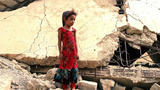 Une fillette yéménite, déplacée avec sa famille, se tient au milieu des ruines d’un immeuble détruit par des frappes aériennes de la coalition menée par l’Arabie saoudite, dans la province de Hajjah au nord-ouest du Yémen, le 3 août 2019. ©AFP - Essa Ahmed