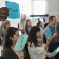 Audience voting with signs at town hall meeting - Photos