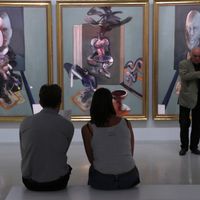 Des visiteurs de l’exposition « Bacon en toutes lettres » au Centre Pompidou devant « Triptyque (1976) » de Francis Bacon.