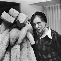 Louise Bourgeois posant à côté de sa sculpture intitulée "Baroque" au Museum of Modern Art à New-York, le 1e février 1983.