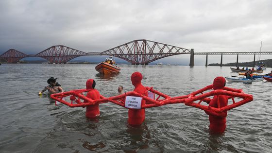 South Queensferrry, Écosse - 1er janvier 2018 : les nageurs du Nouvel An, beaucoup en costume, devant le pont ferroviaire Forth lors de la natation annuelle Loony Dook Swim dans la rivière Forth. ©Getty - Photo par Jeff J Mitchell / Getty Images