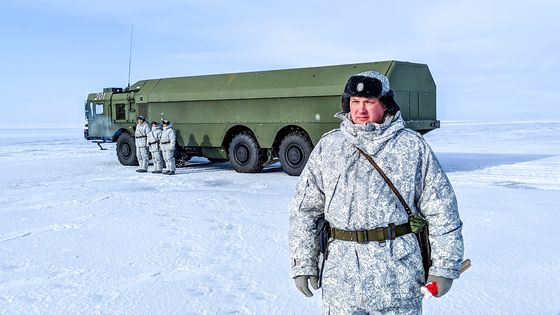 Un officier russe et des soldats se tiennent à côté d'un camion militaire le 3 avril 2019 près de la base militaire du nord de l'île de Kotelny, au-delà du cercle polaire, une région stratégique pour Moscou. ©AFP - Maxime Popov