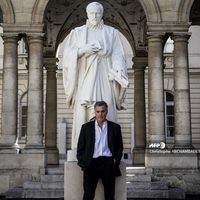 Le cinéaste Amos Gitai pose dans la cour du College de France, devant la statue de Guillaume Budé, Paris, 11 Sept. 2018.