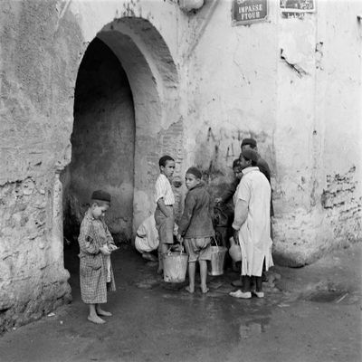 Des enfants vont chercher de l'eau dans une rue de Tunis en octobre 1946.